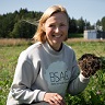 Laura Höijer pellolla kädessään multapaakku