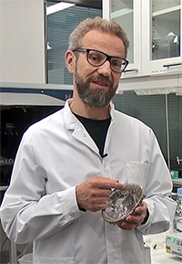 Aalto-yliopiston tutkija Markus LInder esittelee simpukankuorta, jonka helmiäinen koostuu silkki-materiaaleista ja kalsiumkarbonaatista. Kuva: Visa Noronen